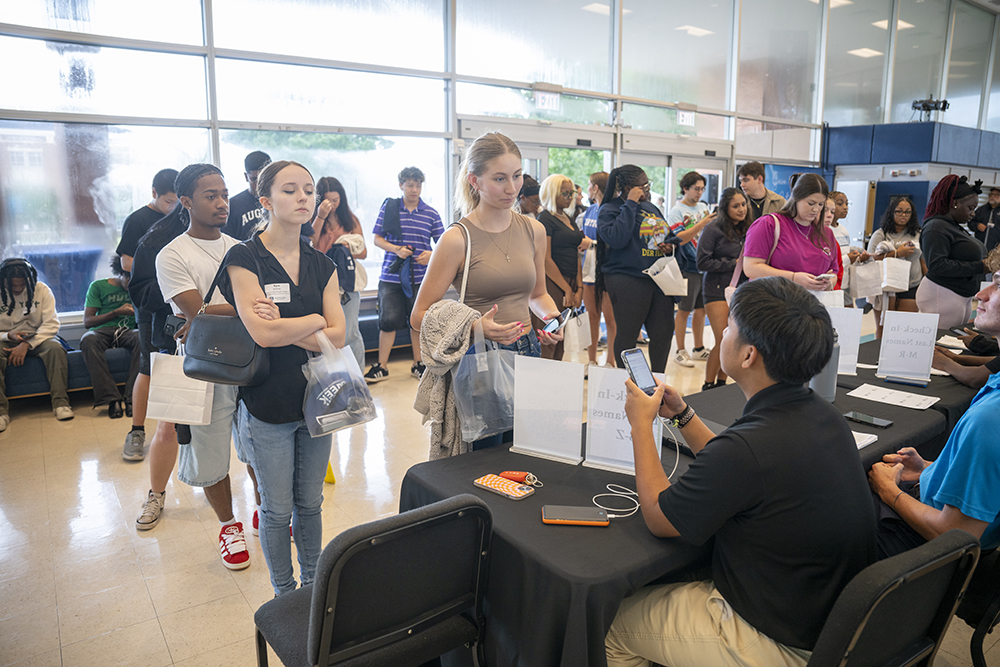 group of students stand in front of a table.
