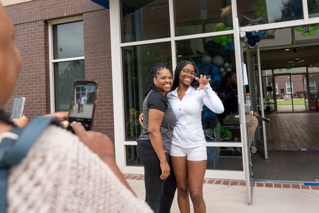 Two women are hugging each other while posing for a picture.