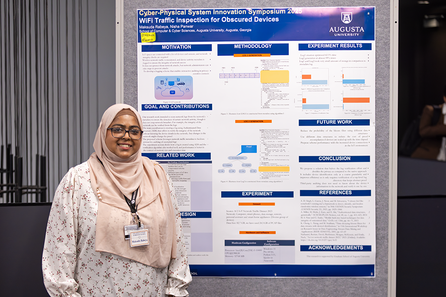A college woman stands next to her scientific poster for her project titled, "WiFi Traffic Inspection for Obscured Devices."