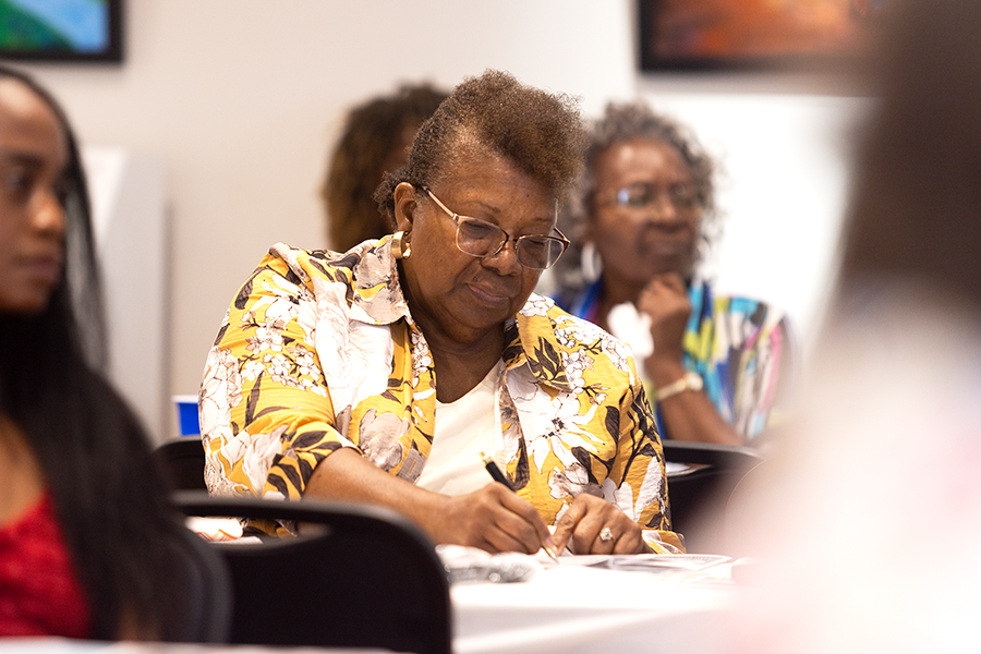 A woman takes notes during a presentation.