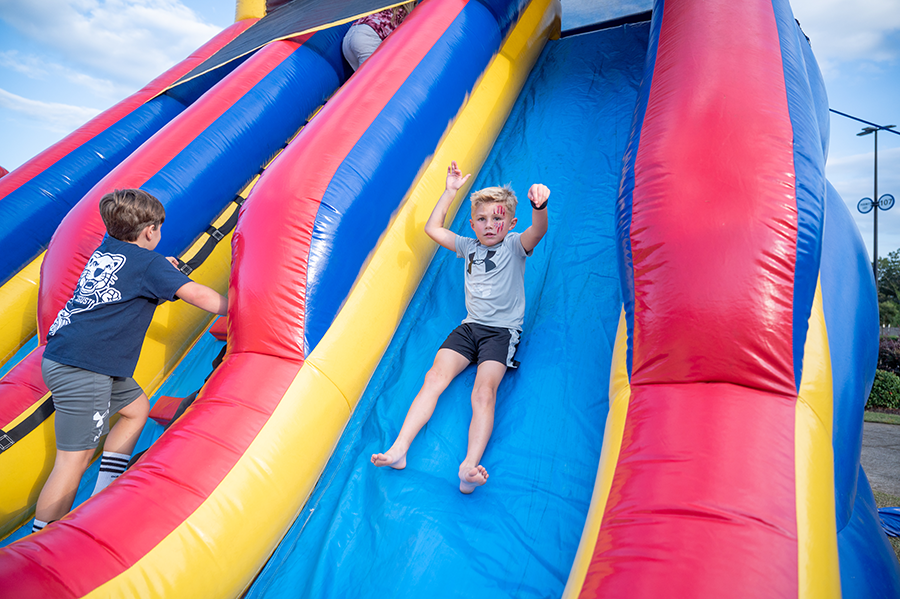 A young boy slides down an inflatable slide.