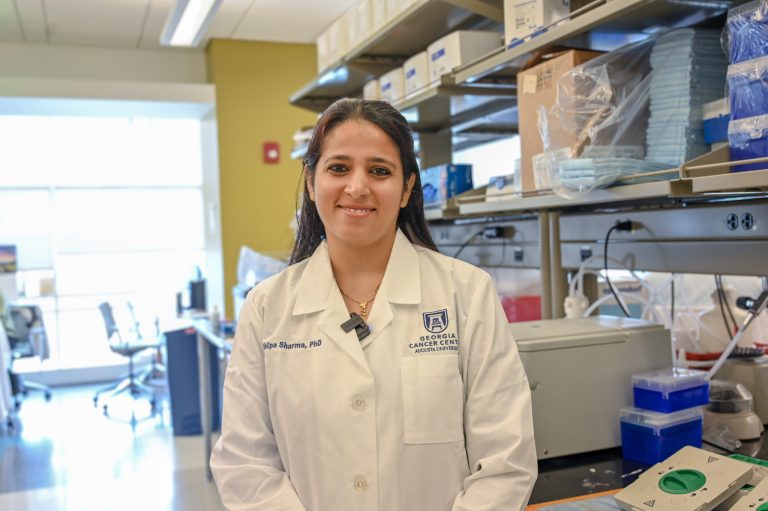 Woman wearing a scientific lab coat standing in a research lab.