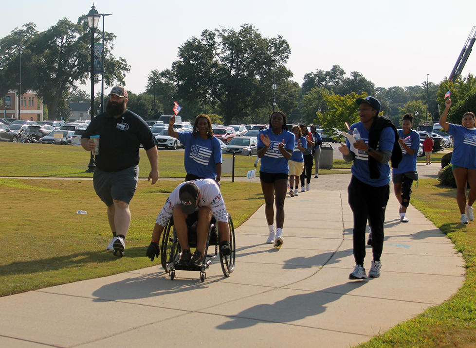 Man in a wheelchair getting cheered on by female spectators