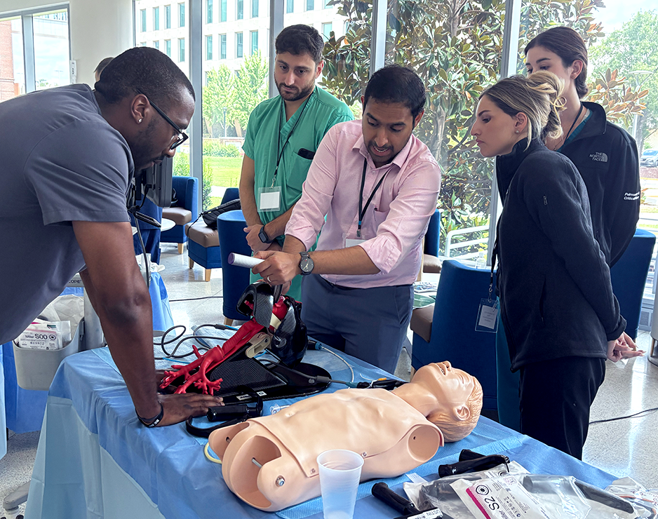 A pulmonologist shows pulmonology fellows a way to put in a breathing tube.