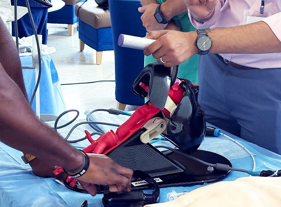 A close up of a pulmonologist showing fellows how to insert a breathing tube.