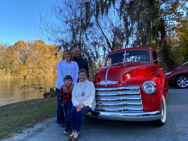 Family posing with a classic pickup truck
