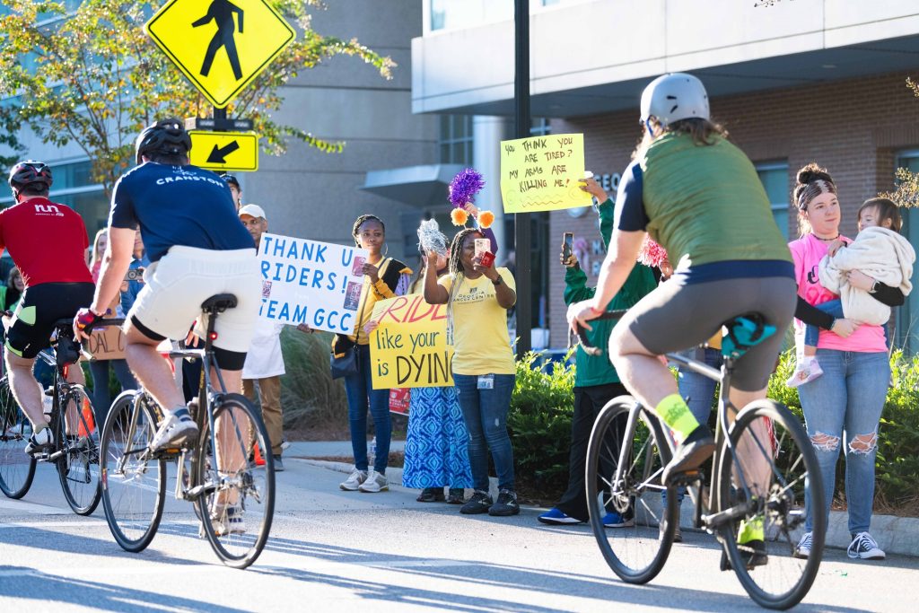 People on bicycles riding past the Georgia Cancer Center's M. Bert Storey Research Building.