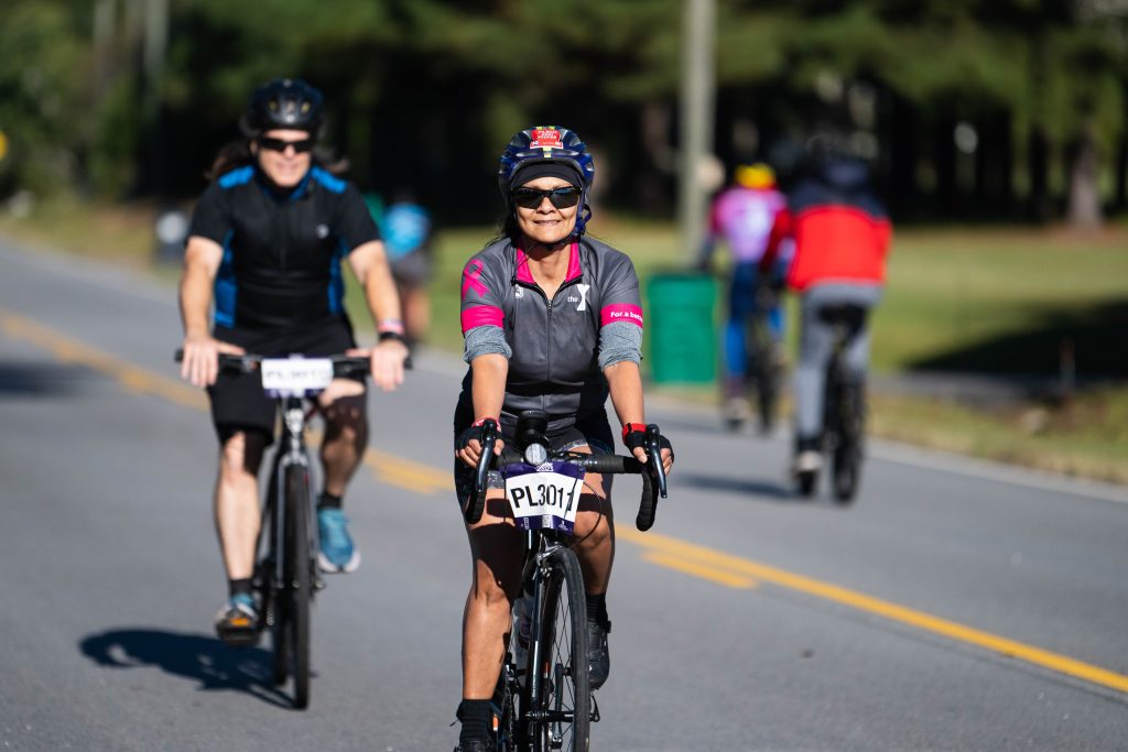Men and women ride bicycles on a street during Paceday 2023.