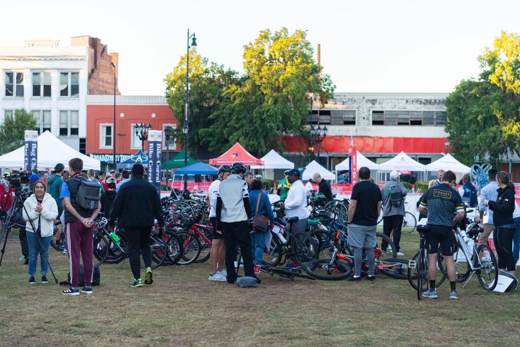In this photo, you see a crowd of people standing on grass at the Augusta Common.