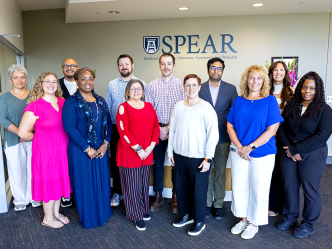 A group of people who work in simulation education pose for a photo.