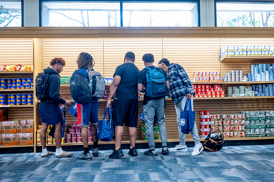 A group of five college students gather food and other supplies from a free store following a storm.