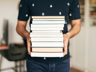 A person holding a stack of books