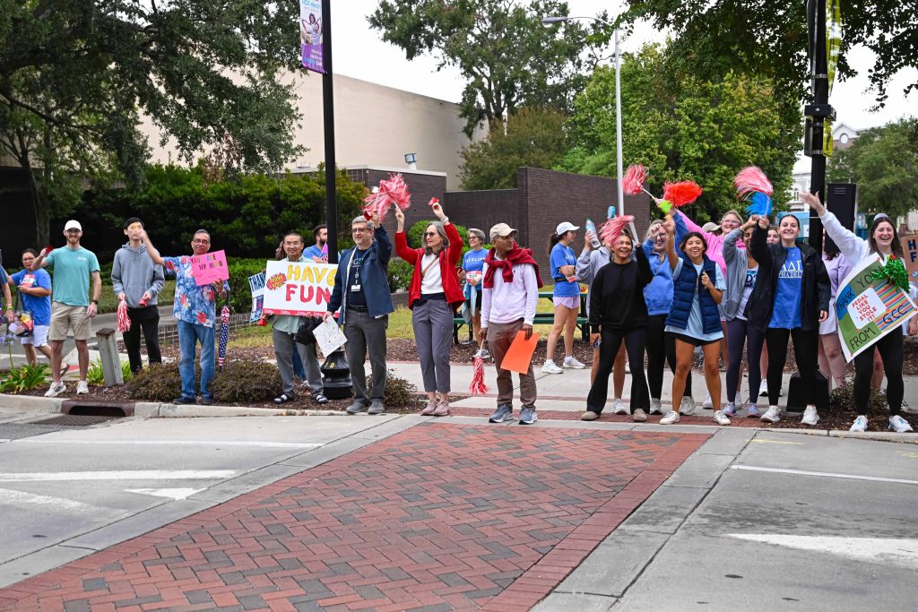 In this photo, you see people standing on the sidewalk to cheer on cyclists taking part in the PaceDay 2025 fundraising event for cancer research projects at the Georgia Cancer Center.