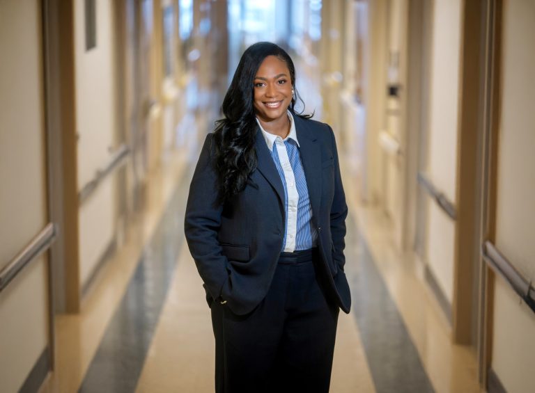 A woman stands in the hallway of a hospital.