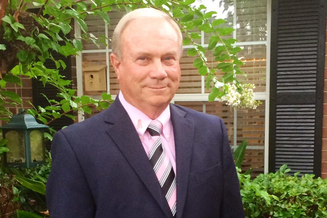 Man in front of window smiling