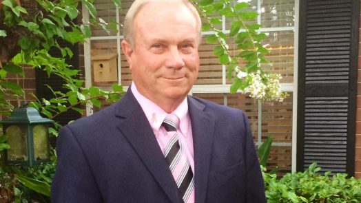 Man in front of window smiling