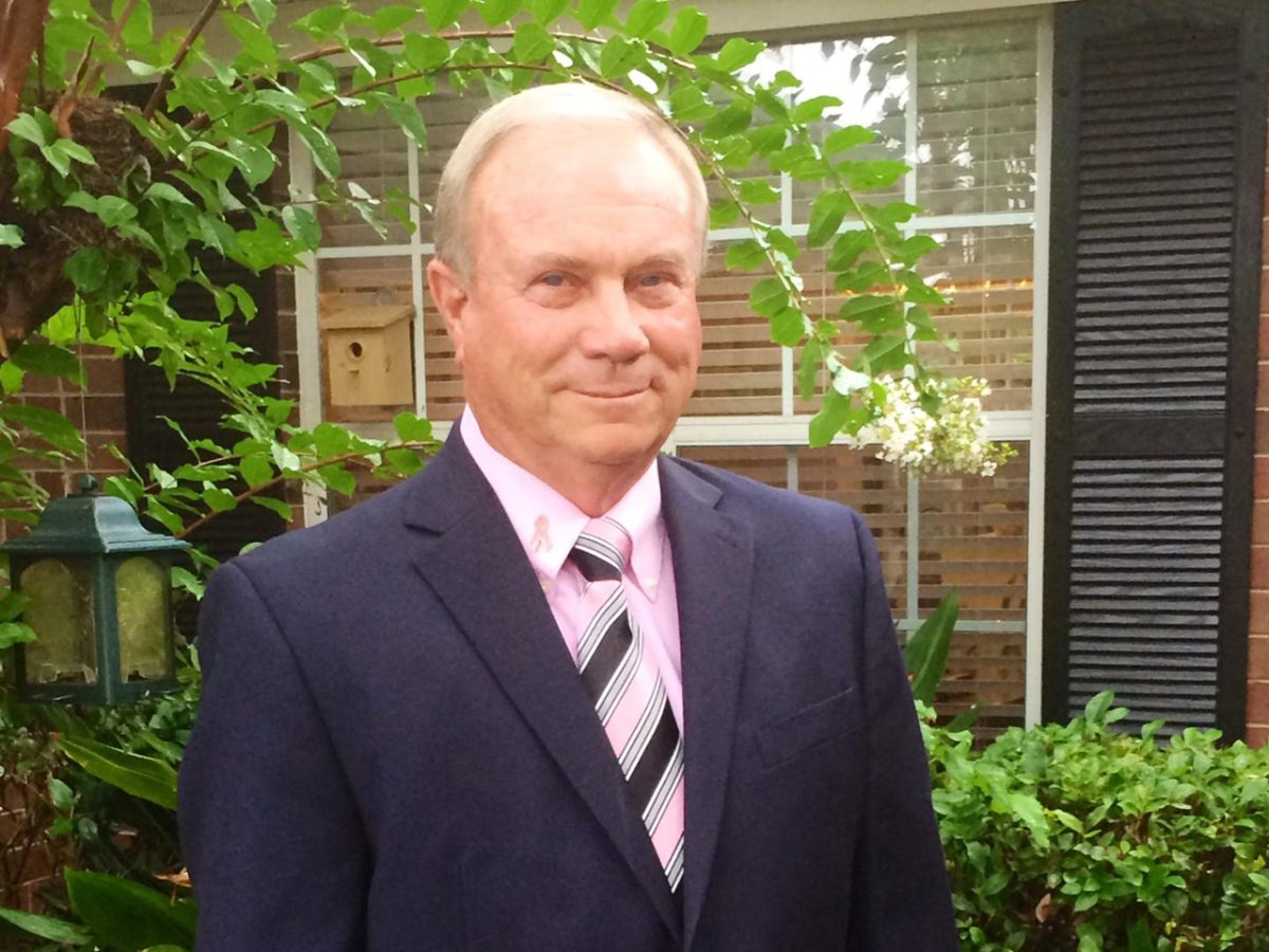 Man in front of window smiling
