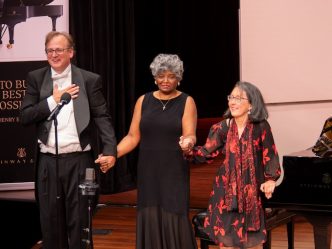 People on stage holding hands for a celebration