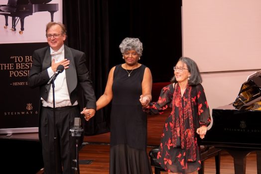 People on stage holding hands for a celebration