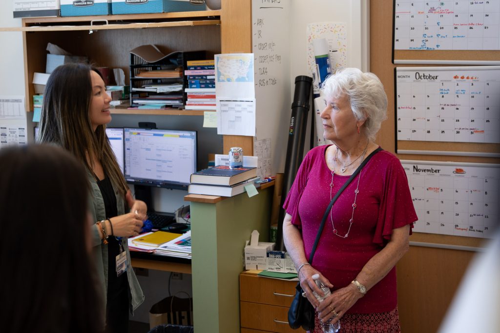An older woman tours a scientific lab and gets a tour from a college-aged woman.