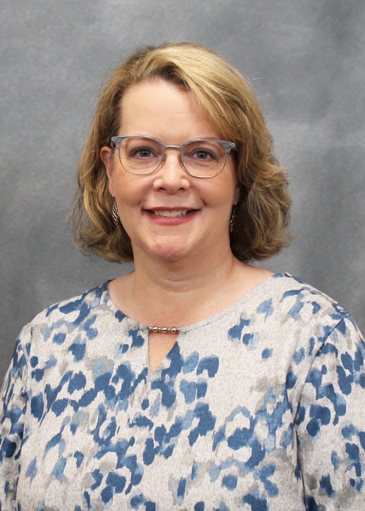 A woman smiles for a photo. 