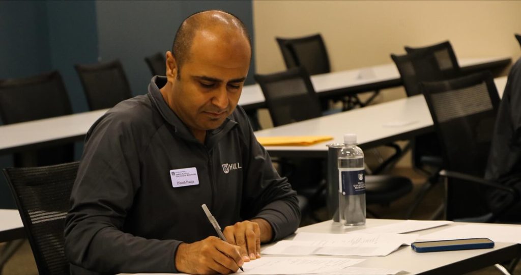 A male college professor grades students on presentations.