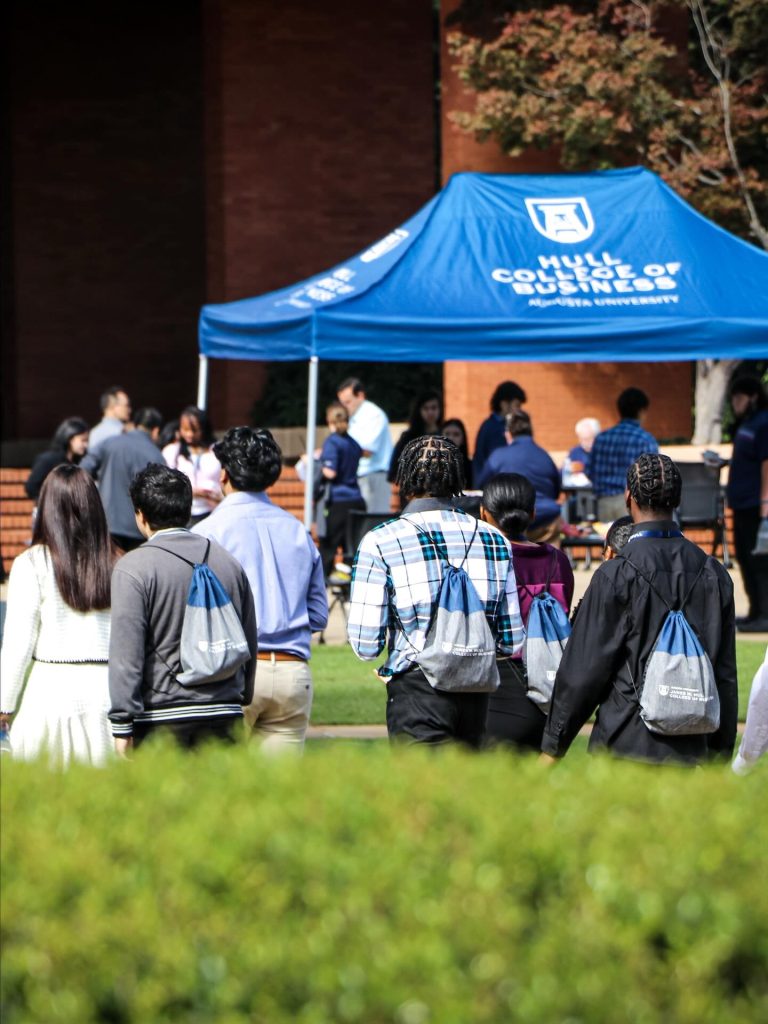 High school students walk on a college campus during a competition and campus visit.