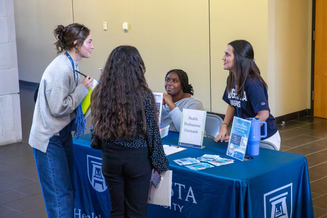 four students talking at a table