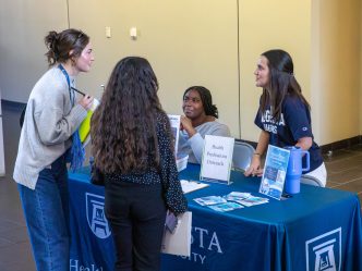 four students talking at a table