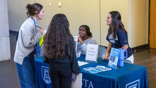 four students talking at a table