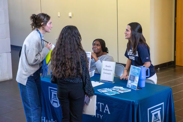 four students talking at a table