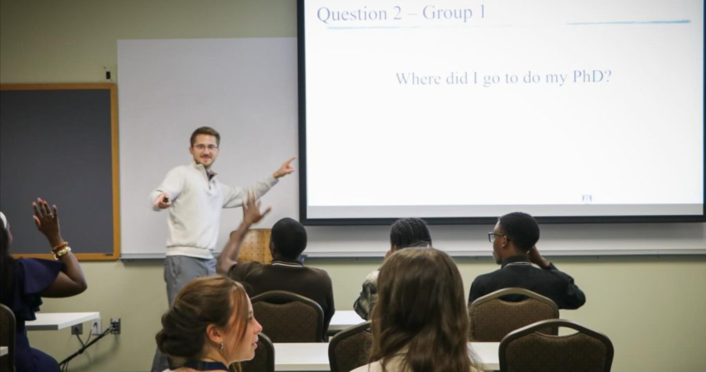 A male college professor takes questions from high school students during a special presentation.