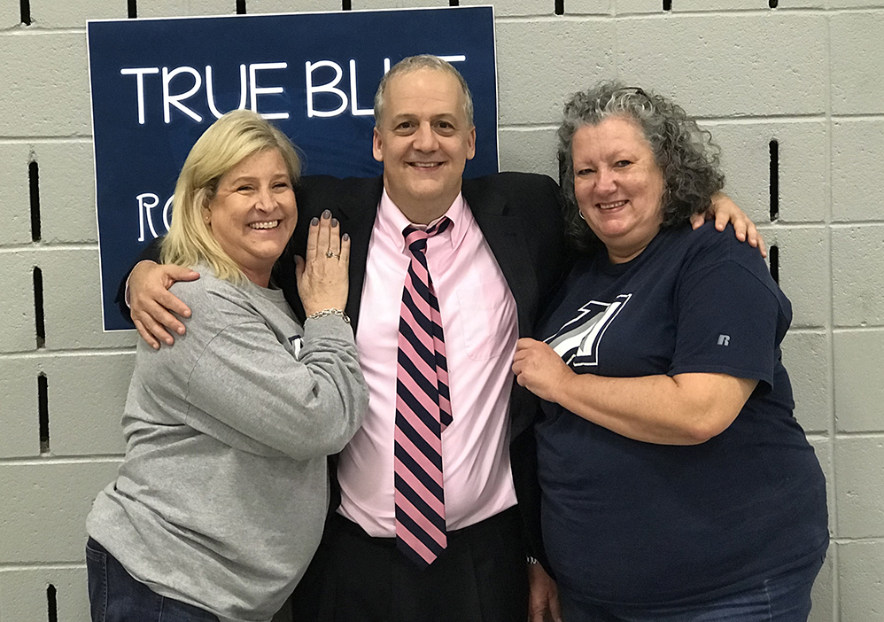 Two women and a man posing for a photo smiling