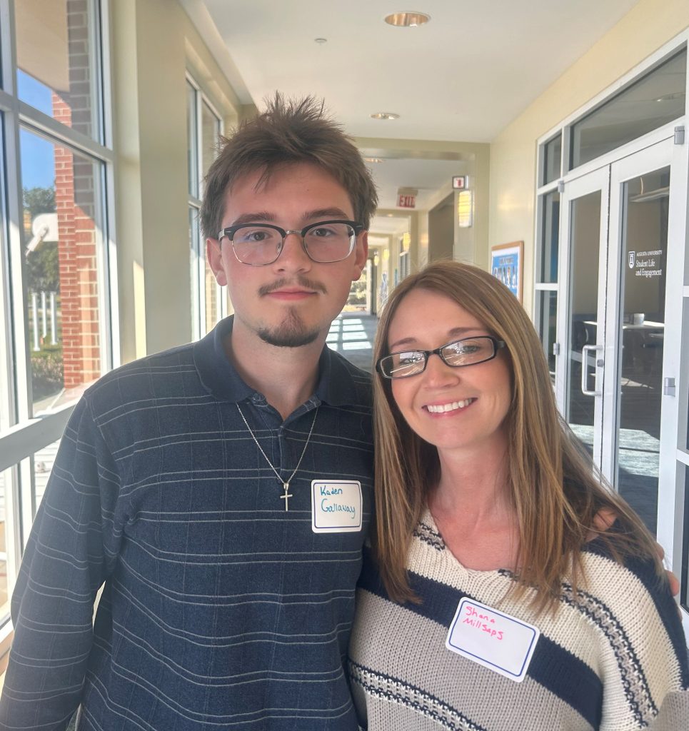 A male high school student and his mom on a college tour.