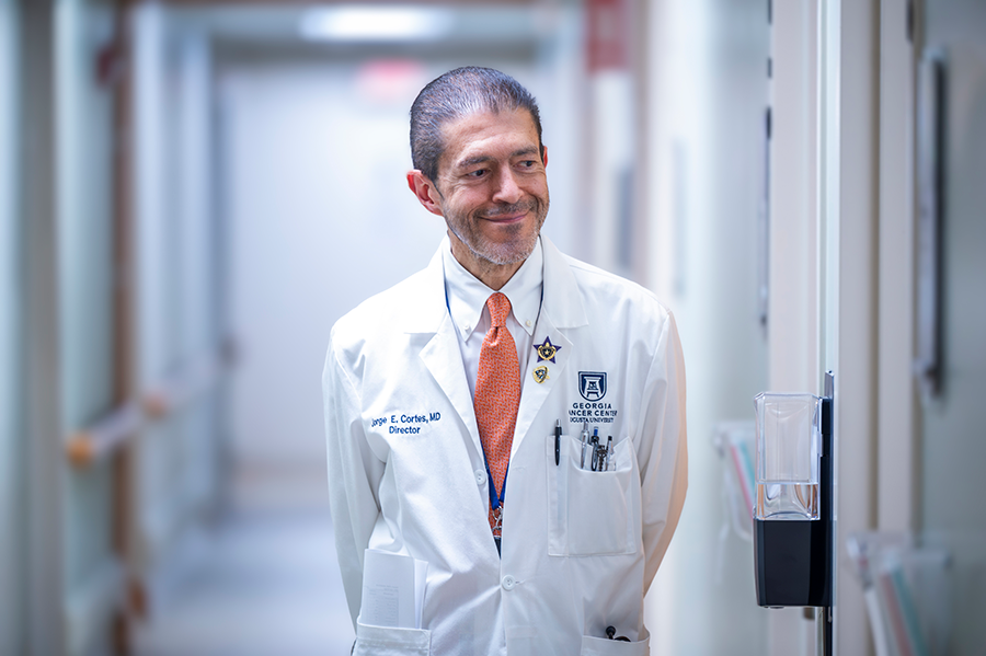 A male doctor walking down the hall of a hospital.