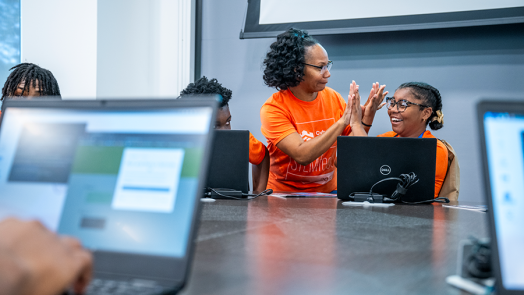 A woman and a high school girl give each other high fives during a competition.