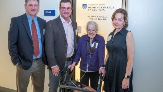 two men and two women in front of door to laboratory