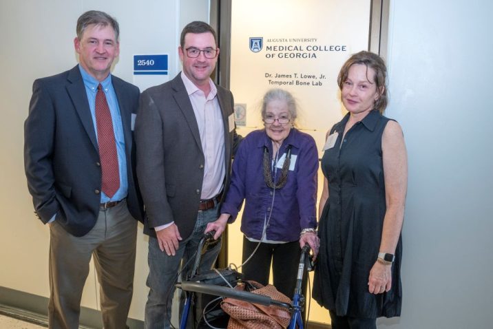 two men and two women in front of door to laboratory