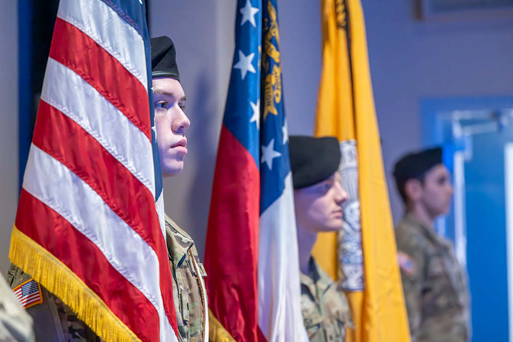 Three young men and three flags during a flag presentation.