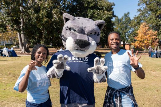 Augusta University mascot, Augustus, with two female students.