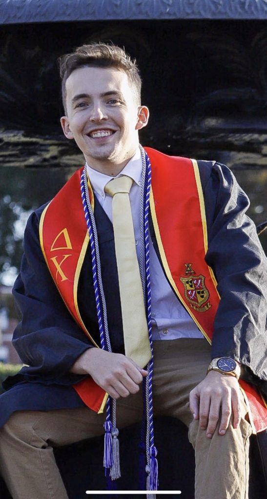 A male college student wearing a graduation robe and stole.