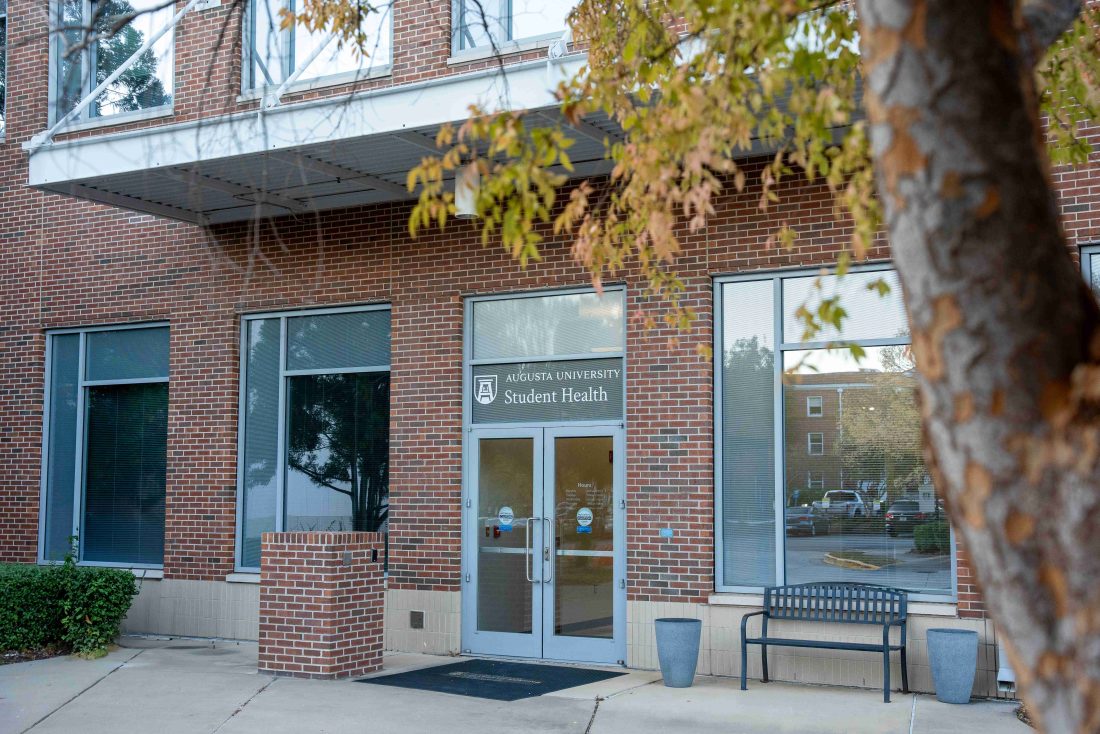 Brick building with a tree on the right side.