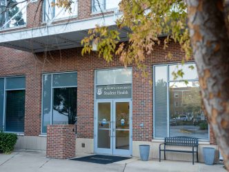 Brick building with a tree on the right side.