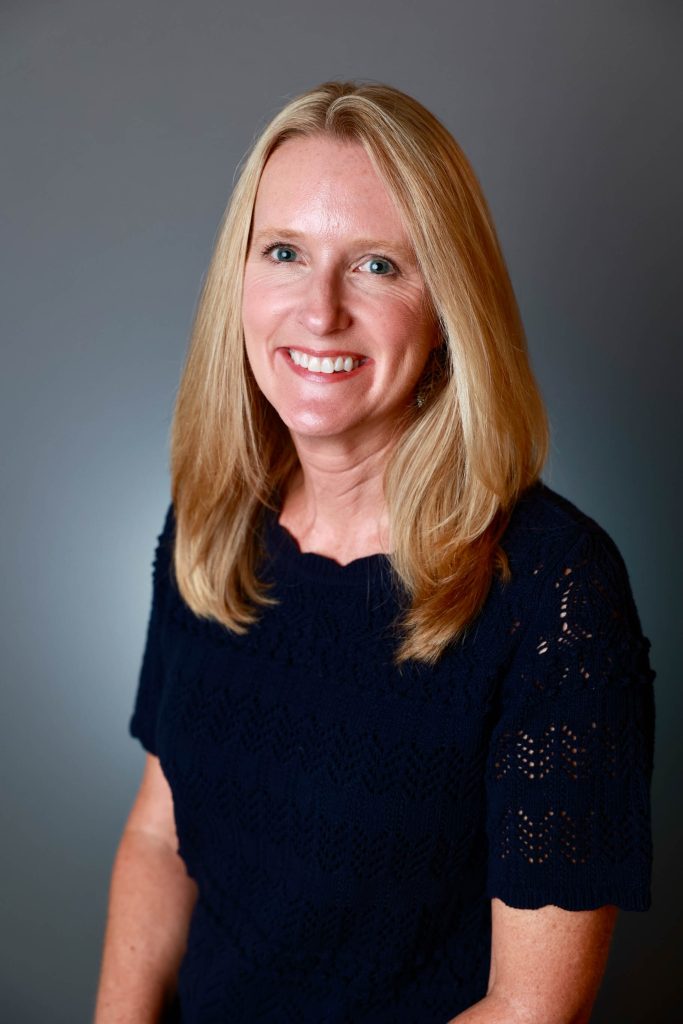 A woman smiles for a photo. 