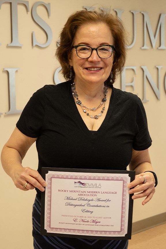 woman smiling while holding a certificate