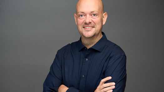 A man stands with his arms crossed in front of him.