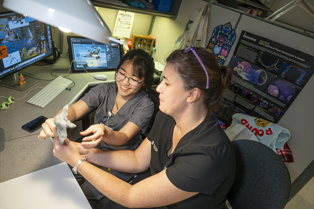Two women reviewing a sculpture model