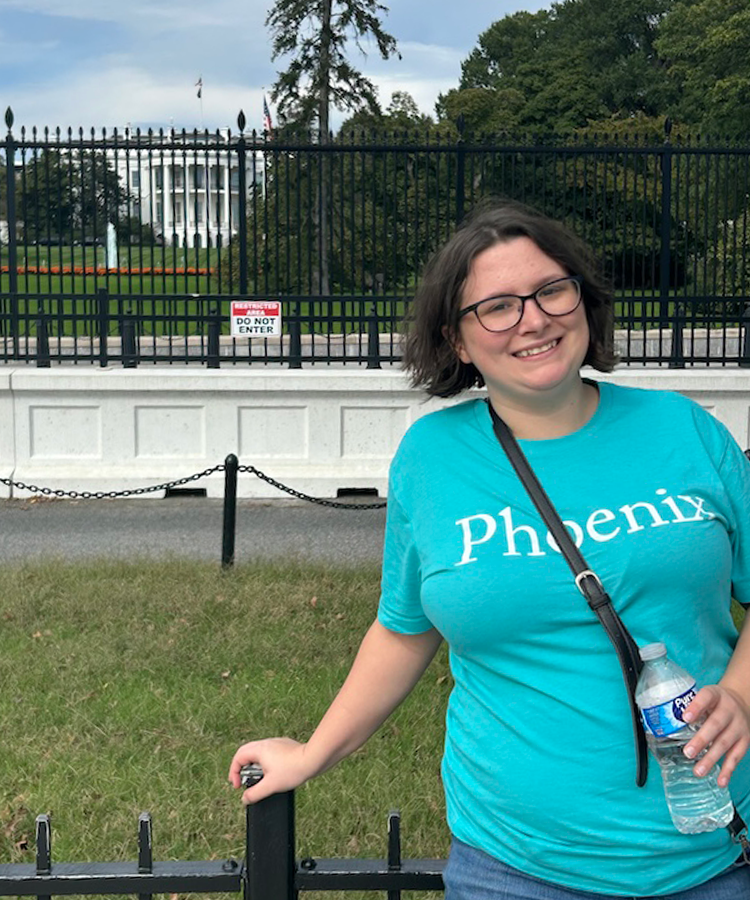 A college-aged woman stands outside the fence around the United States' White House in Washington, D.C.