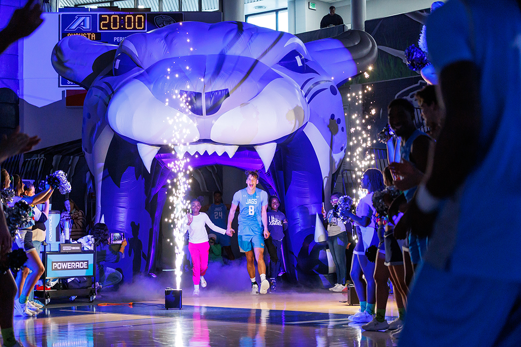 A basketball player running onto the court with a two fifth-graders