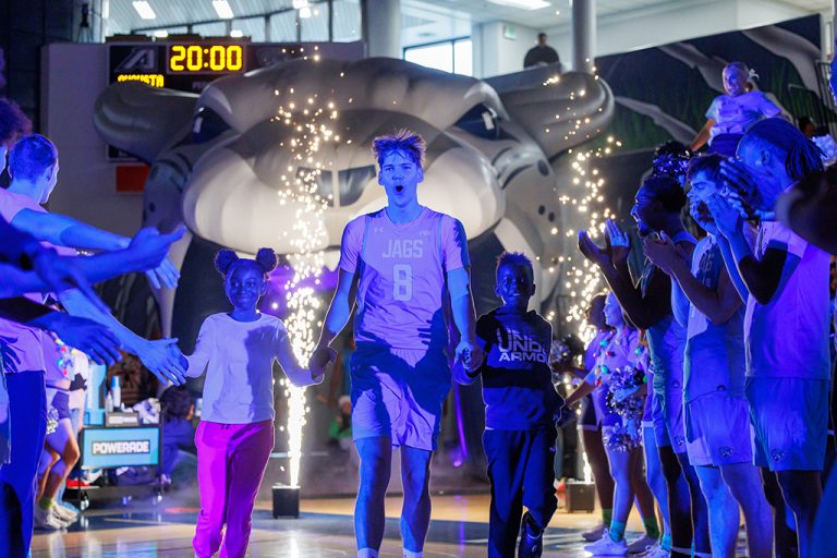 Male and female students running on to a court